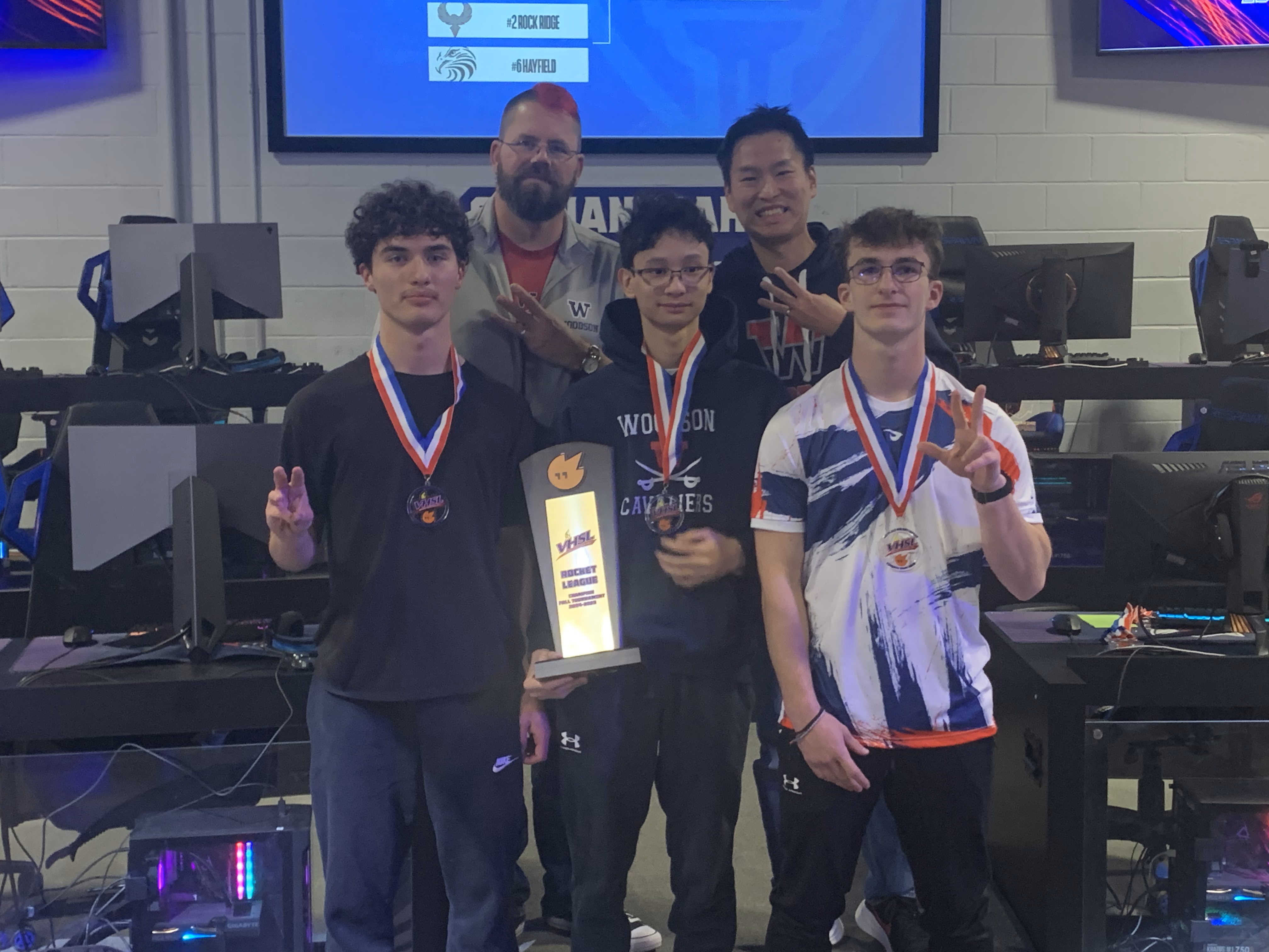 Woodson Esports Rocket League players and coach pose with Championship trophy