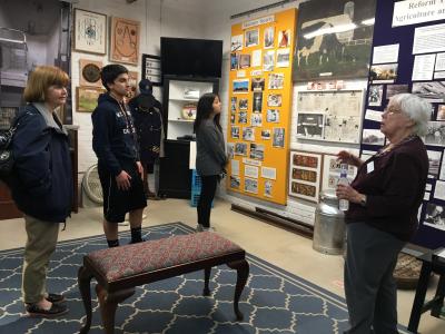 Students looking at history display with curator