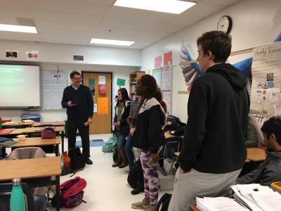 Students standing and talking with teacher
